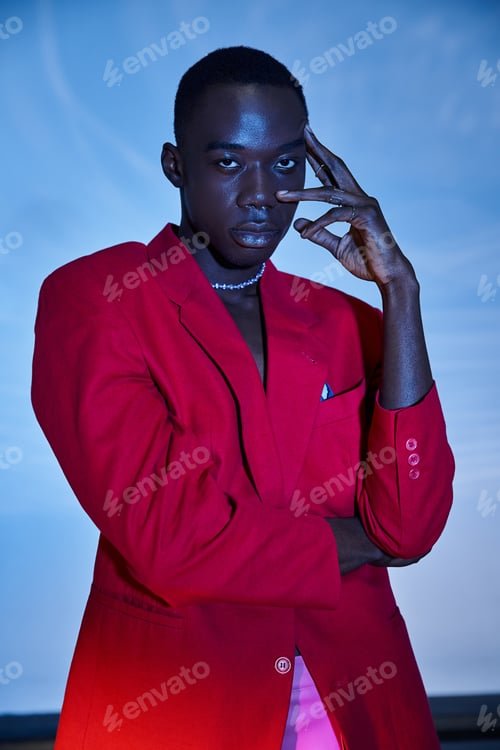 Preview: handsome sexy african american man in red vivid blazer looking at camera on blue watery background