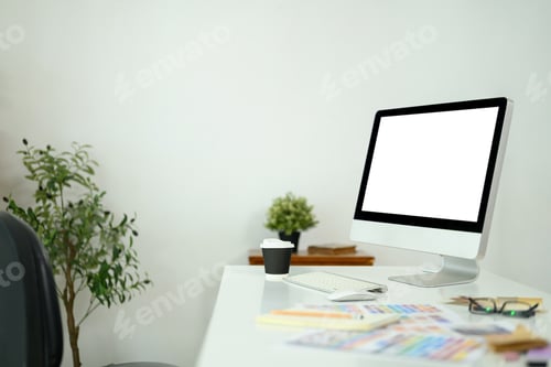 Preview: Creative workspace with computer monitor, color palettes, and design materials