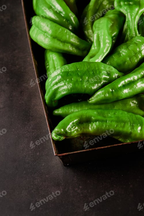 Preview: Vertical closeup shot of a box full of green chili peppers also known as Anaheim Pepper