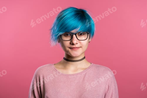 Preview: Portrait of young punk unusual woman with blue hair on pink background. Girl in transparent glasses