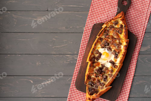 Preview: Turkish stuffed flatbread pide on gray wooden table