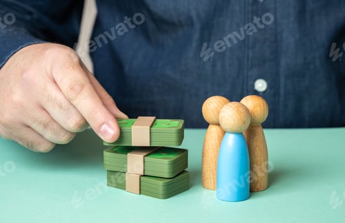 Preview: A man puts money near the figures of people. Investments in a business team or startup
