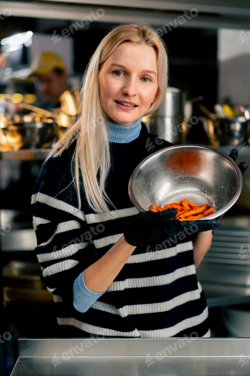 Preview: a young girl in the kitchen stands with a bowl of sweet potato demonstrating looking at the camera
