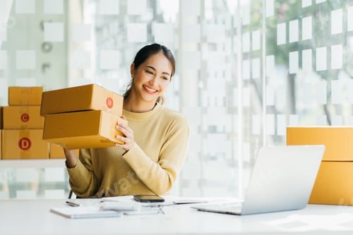 Preview: Portrait young attractive asia female owner startup business work happy with box at home prepare
