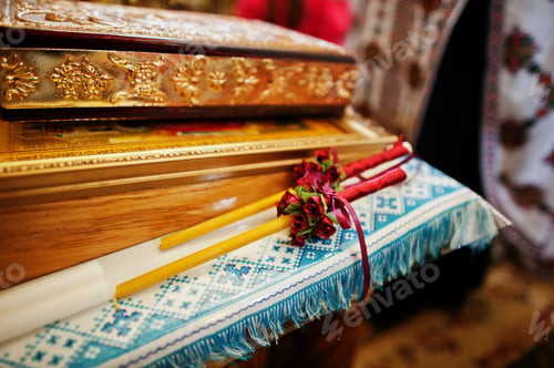 Preview: Close-up photo of two decorated candles in the church on wedding ceremony.