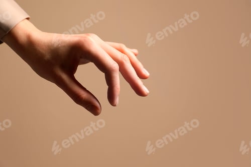 Preview: Woman holding something in hand on beige background, closeup. Space for text