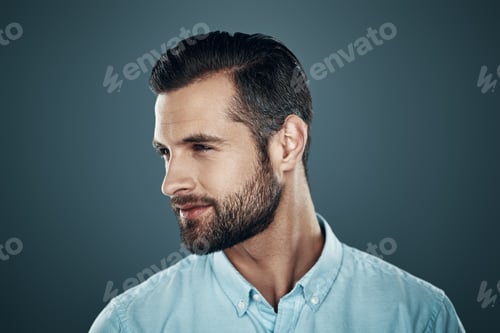 Preview: So charming! Handsome young man smiling and looking away while standing against grey background
