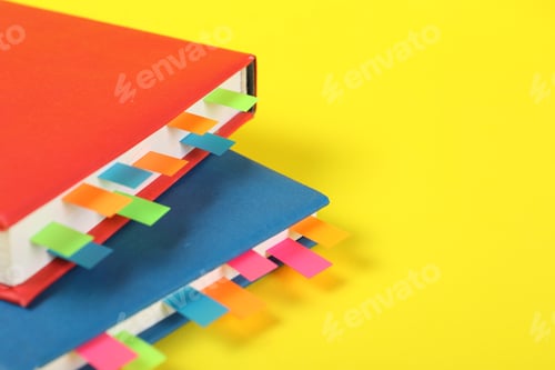 Preview: Books with colorful tabs on yellow background, closeup. Space for text