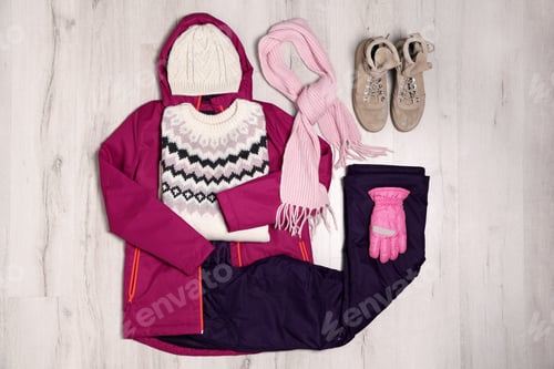 Preview: Flat lay composition with female clothes for winter vacation on wooden background