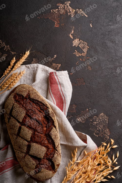 Preview: Freshly baked homemade bread on artisan sourdough rye on brawn stone or concrete background. Top vie