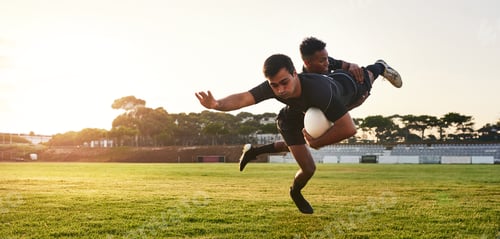 Preview: Full length shot of two handsome sportsmen playing rugby during a training session during the day