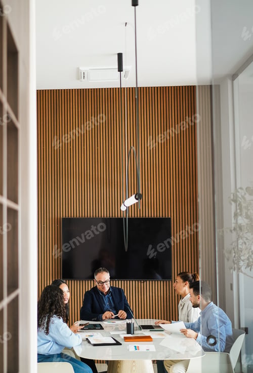 Preview: Multiracial colleagues working inside business office with glass walls