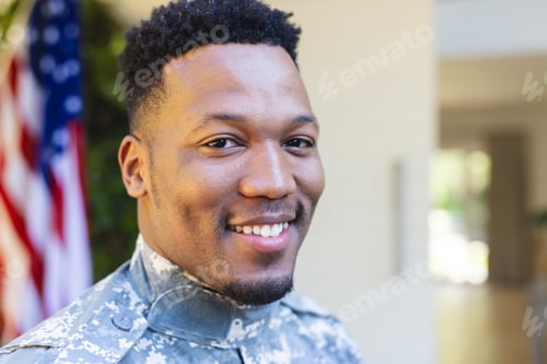 Preview: Happy african american male soldier face close up outside home with usa flag, copy space