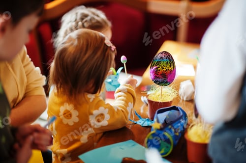 Preview: Preparing to Easter concept. Kids making by hands bunny and eggs.