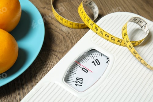 Preview: Scales, measuring tape and oranges on wooden background, closeup. Weight loss