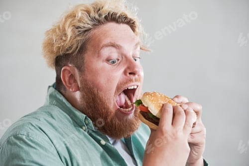 Preview: Man eating fast food with pleasure