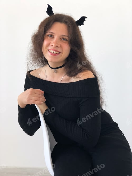 Preview: Smiling woman with Halloween bat wings on hair. Halloween, festivity and creativity concept