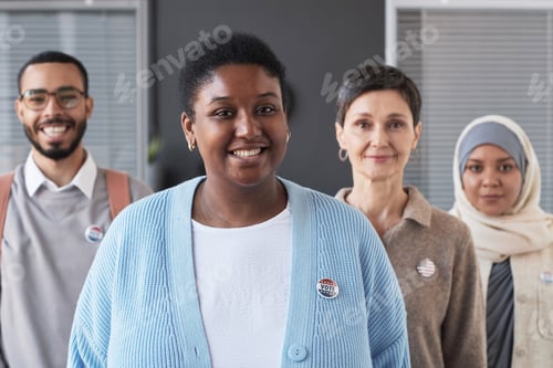 Preview: Happy young African American woman with small round vote badge on chest