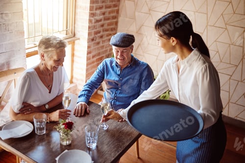 Preview: Restaurant waitress, wine glass and service to happy couple for lunch celebration on fine dining da