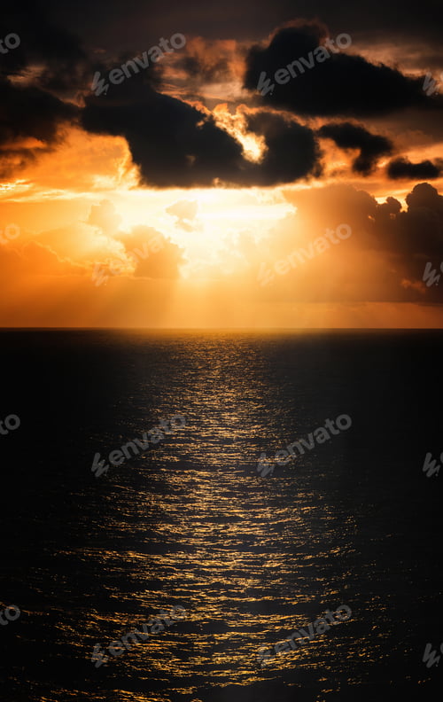 Preview: Beautiful orange and pink sunset sky over the ocean horizon, with wispy clouds