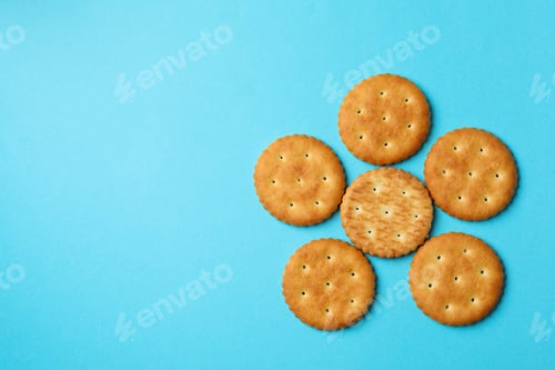 Preview: Tasty cracker biscuits on blue background, top view