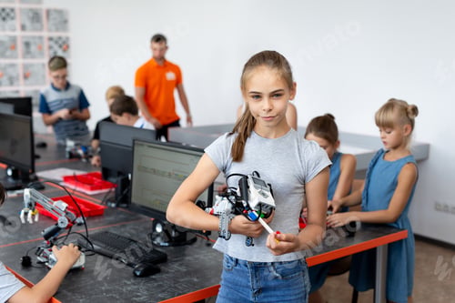 Preview: Portrait Of Female Student Building Robot Vehicle In After School Computer Coding Class.