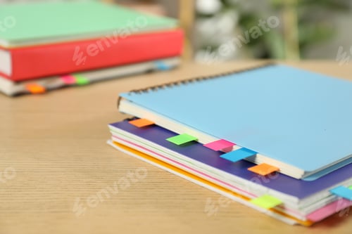 Preview: Notebooks with colorful tabs on wooden table, closeup