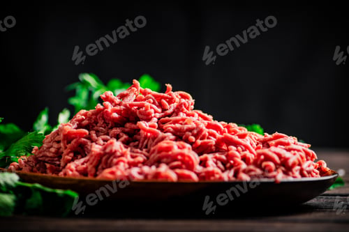 Preview: Minced meat on a plate on the table with parsley.