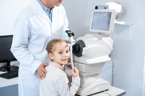 Preview: cropped image of ophthalmologist and adorable pre-adolescent child in clinic