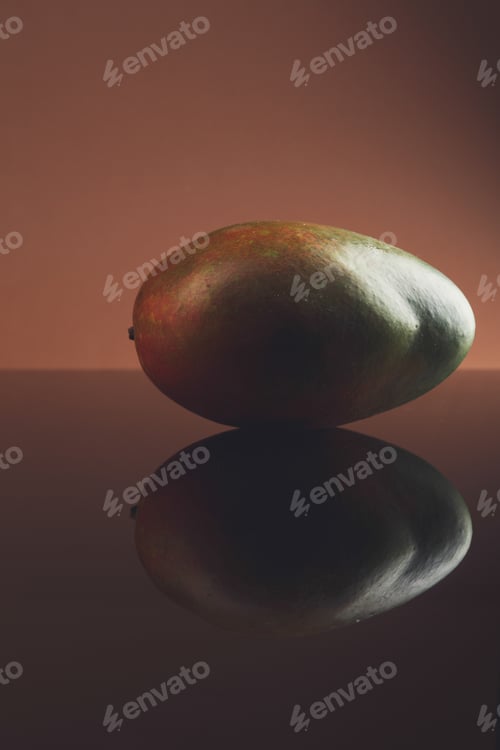 Preview: Ripe mango on dark glass background with reflection