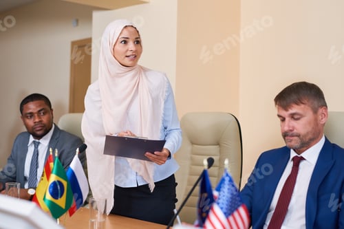 Preview: Young muslim female in hijab making report at conference