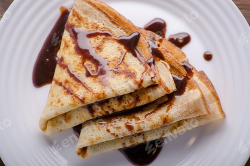 Preview: Flat lay French crepes with chocolate sauce in ceramic dish on w