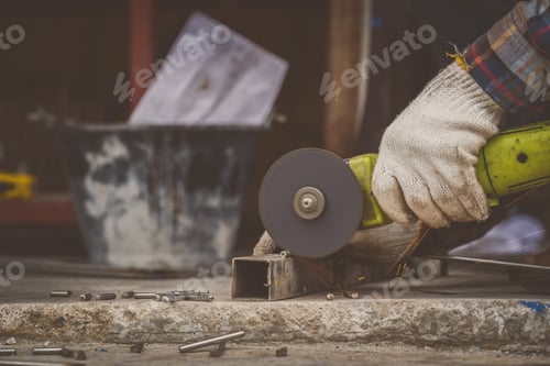 Preview: Metal Worker Using Grinder on Metal Square Tubing