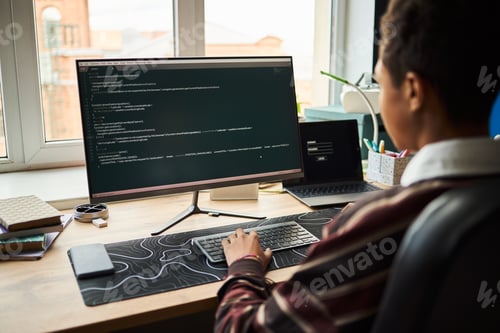 Preview: Young Adult Black Man Working on Computer Programming Code in Modern Office