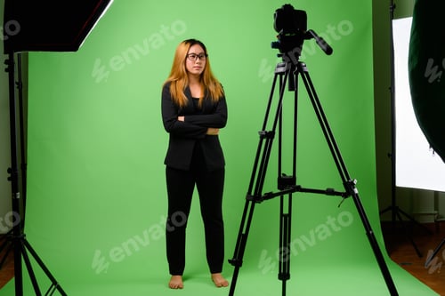 Preview: Portrait of young Asian businesswoman against green background