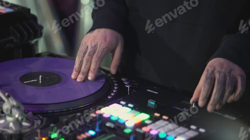 Preview: DJ mixes the music on the remote. Art. A man adjusts the music on the remote. The guy with tattoos