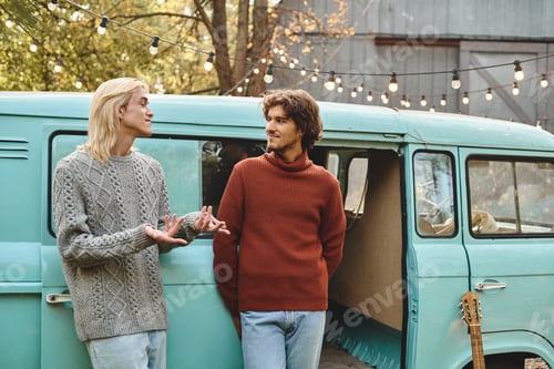 Preview: Young lgbt couple sharing a moment by a vintage van in a cozy autumn setting