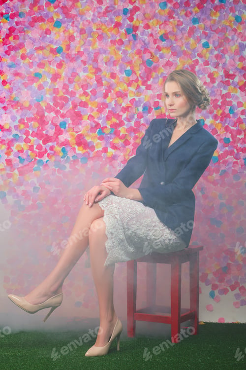 Preview: Full length portrait of cute girl in blue jacket and lace skirt sitting on chair