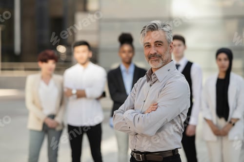 Preview: Businessman standing in front of her colleagues