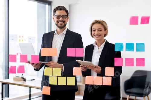 Preview: Business professionals brainstorming ideas with sticky notes on glass board