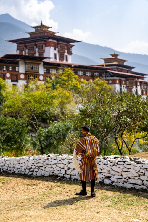 Preview: Man in traditional Bhutanese attire at Punakha Dzong.