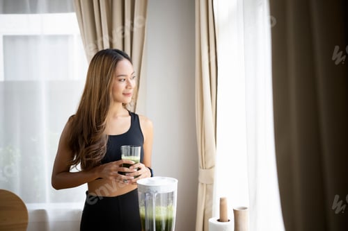 Preview: Beautiful young asian woman drinking green detox vegetable smoothie. Healthy Lifestyle concept.
