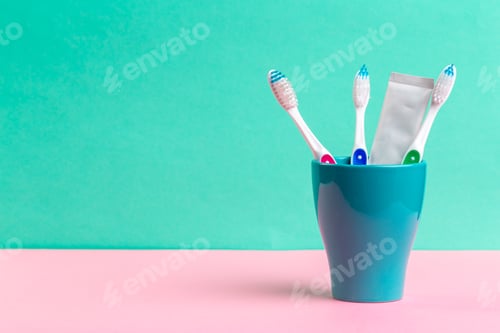 Preview: Toothbrushes in glass on the table. creative photo