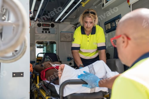 Preview: Paramedics providing first aid to injured patient in ambulance