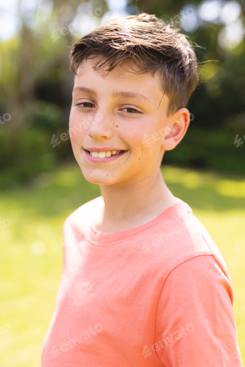 Preview: Portrait of young boy caucasian women wearing orange t-shirt and standing in the garden