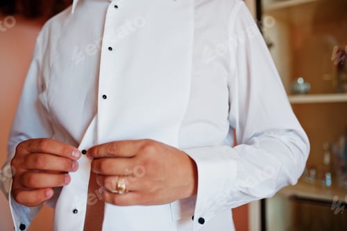 Preview: Torso of Man Buttoning a Crisp White Shirt