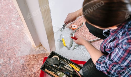 Preview: Female plumber doing heating installation on a construction site