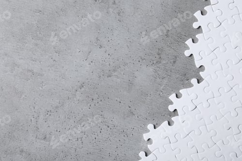 Preview: Blank white puzzle pieces on light grey stone background, flat lay. Space for text