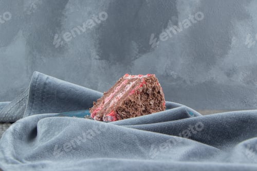 Preview: A cake slice on a platter nested on a tablecloth on marble background