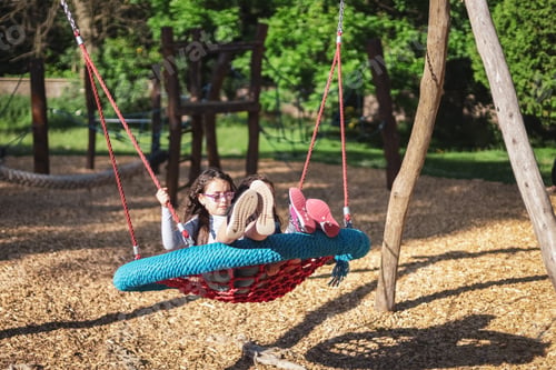 Preview: Two caucasian girls flying at speed with hair fluttering in the wind sitting on a round rope